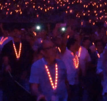 Audience wearing synchronized LED lanyards at concert