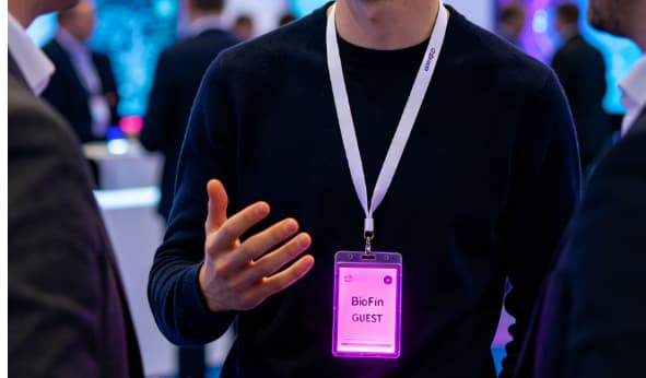 Corporate product launch event with DMX controlled LED lanyards in brand color zones for audience engagement