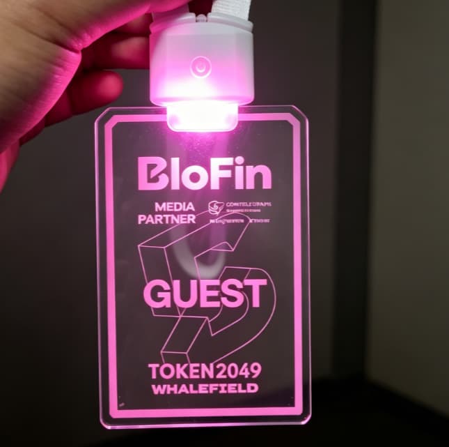 Event attendee tapping LED lanyard button to cycle through colors during interactive concert experience