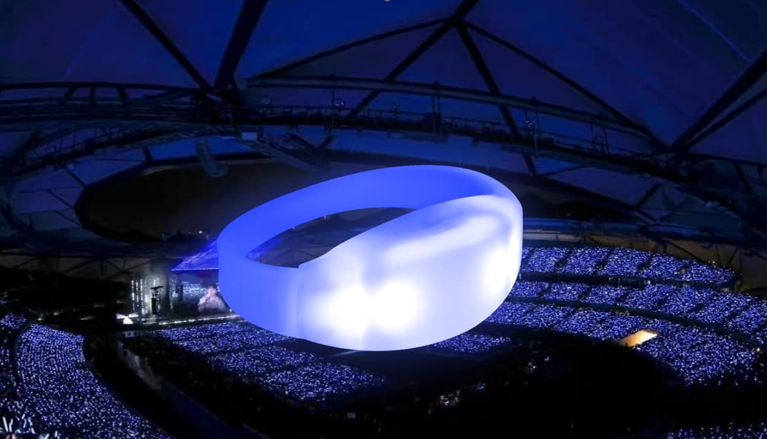 Massive arena concert deployment of GFLAI PRO wholesale light up bracelets syncing to live venue music tracks via sub-GHz RF data streaming